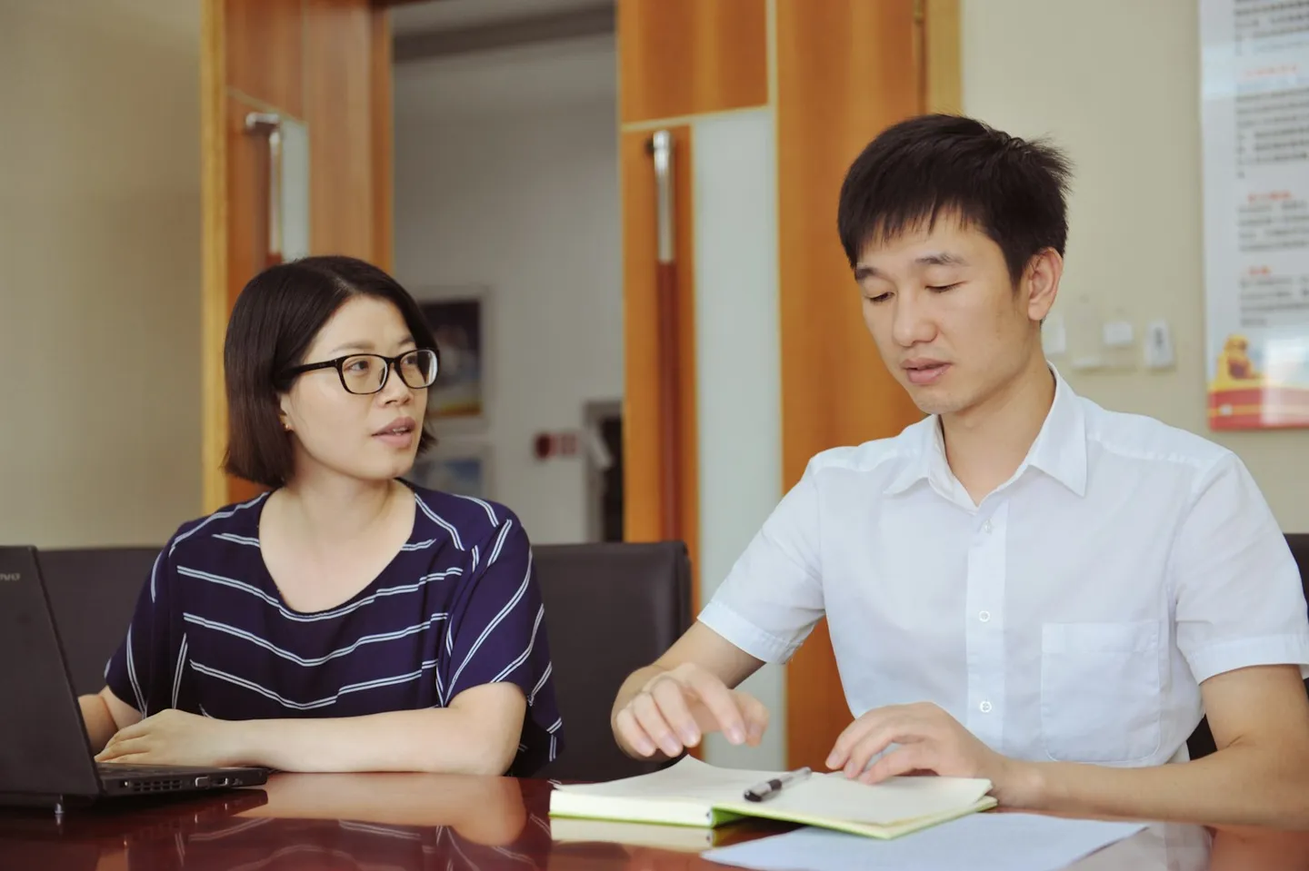 兩位同事坐在桌邊討論工作