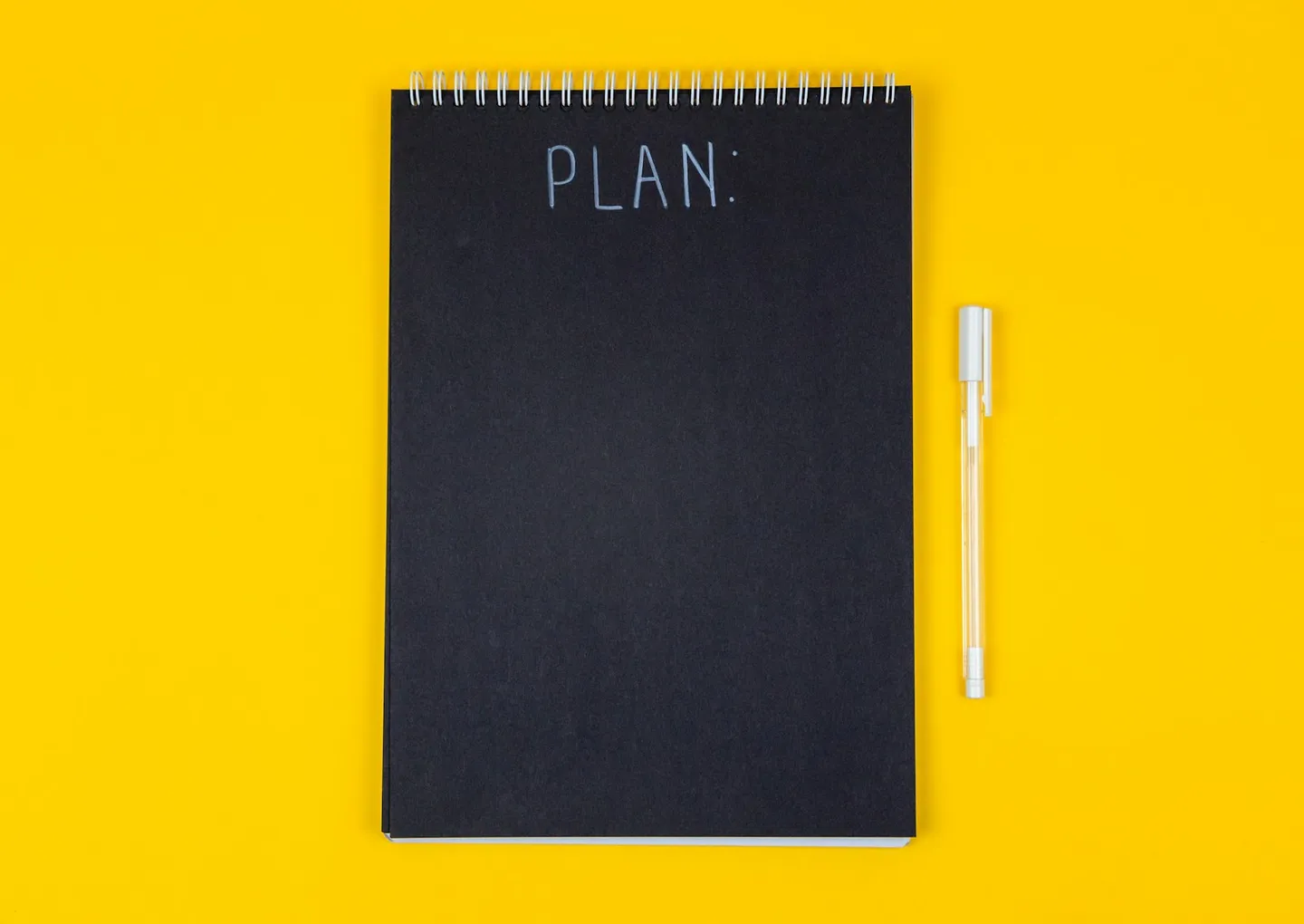 黃色背景上寫著 PLAN 的黑色筆記本